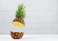 Fresh ripe flying cut juicy pineapple on gray brick wall background Royalty Free Stock Photo