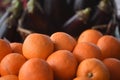 Fresh ripe fruit of oranges piled up with dark background of aubergines Royalty Free Stock Photo