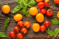 Fresh ripe garden tomatoes and basil on wooden table Royalty Free Stock Photo