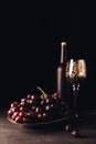 fresh ripe grapes glass and bottle of wine on wooden table Royalty Free Stock Photo