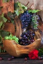 Fresh ripe grapes. Grape harvest. Handmade wooden utensils on the kitchen table. Wooden plates, bowls and dishes on the table. Royalty Free Stock Photo