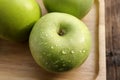 Fresh ripe green apple with water drops on wooden plate. Royalty Free Stock Photo