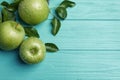 Fresh ripe green apples with water drops on turquoise wooden table, flat lay. Space for text Royalty Free Stock Photo