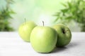 Fresh ripe green apples on white wooden table against blurred background. Space for text Royalty Free Stock Photo