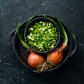 Fresh ripe green spring onions with fresh chopped green onions on black stone background. Royalty Free Stock Photo