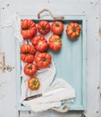 Fresh ripe hairloom tomatoes in rustuc blue wooden tray