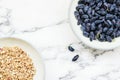 Fresh ripe honeysuckle berries in a ceramic bowl and bowl of muesli Royalty Free Stock Photo