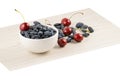 Fresh ripe honeysuckle berries and cherry in a ceramic bowl on a wooden board. Healthy breakfast. White bowl of honeysuckle. Royalty Free Stock Photo