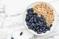 Fresh ripe honeysuckle berries and muesli in a ceramic bowl on a grey marble table Royalty Free Stock Photo