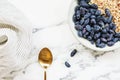 Fresh ripe honeysuckle berries and muesli in a ceramic bowl on a grey marble table Royalty Free Stock Photo