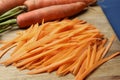 Fresh ripe juicy carrot sticks and whole vegetables on wooden board, closeup Royalty Free Stock Photo