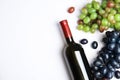 Fresh ripe juicy grapes, bottle of red wine and space for text on white background Royalty Free Stock Photo