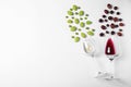 Fresh ripe juicy grapes and glasses of wine on white background Royalty Free Stock Photo