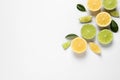 Fresh ripe lemons, limes and green leaves on white background, top view Royalty Free Stock Photo