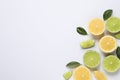 Fresh ripe lemons, limes and green leaves on white background, top view Royalty Free Stock Photo