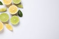 Fresh ripe lemons, limes and green leaves on white background, top view Royalty Free Stock Photo