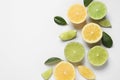 Fresh ripe lemons, limes and green leaves on white background, top view Royalty Free Stock Photo