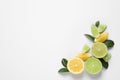 Fresh ripe lemons, limes and green leaves on white background, top view Royalty Free Stock Photo