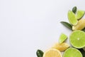 Fresh ripe lemons, limes and green leaves on white background, top view Royalty Free Stock Photo