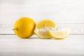 Fresh ripe lemons, slices, rustic food photography on white wood plate kitchen table