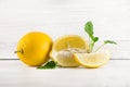 Fresh ripe lemons, slices, rustic food photography on white wood plate kitchen table