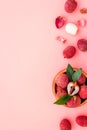 Fresh ripe lychee in bowl on pink desk top-down frame copy space Royalty Free Stock Photo