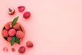 Fresh ripe lychee in bowl on pink desk top-down frame copy space Royalty Free Stock Photo