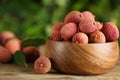 Fresh ripe lychees on wooden table outdoors