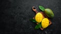 Fresh ripe mango on black stone background. Tropical fruits. Top view. Royalty Free Stock Photo