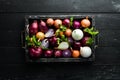 Fresh ripe onions in wooden box on black background. Top view. Royalty Free Stock Photo