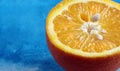 Fresh ripe orange closeup. half an orange on a blue background. copy space. top view