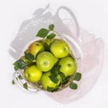 Fresh, ripe orange with leaves in a wicker bag on a white background