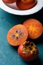 Fresh ripe, orange persimmons slices on a wooden background..