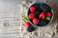 Fresh ripe organic blackberries and raspberries in a blue bowl on rustic wooden table.Summer berries. Royalty Free Stock Photo
