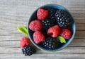 Fresh ripe organic blackberries and raspberries in a blue bowl on rustic wooden table.Summer berries. Royalty Free Stock Photo