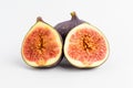 Fresh ripe organic figs on a white table, one whole fig and one sectioned in half, close up with soft focus, top view Royalty Free Stock Photo