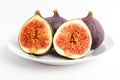 Fresh ripe organic figs on a white table, two whole figs and one sectioned in two parts, close up with soft focus, side view Royalty Free Stock Photo