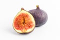 Fresh ripe organic figs on a white table, two whole figs and one sectioned in half, close up with soft focus, top view Royalty Free Stock Photo