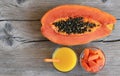 Fresh ripe organic papaya tropical fruit cut in half,sliced and papaya juice in a glass jar on old wooden background. Royalty Free Stock Photo