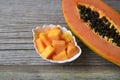 Fresh ripe organic papaya tropical fruit cut in half and sliced on old wooden background. Healthy eating or vegan food concept. Royalty Free Stock Photo