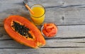 Fresh ripe organic papaya tropical fruit cut in half,sliced and papaya juice in a glass jar on old wooden background. Royalty Free Stock Photo