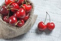 Fresh ripe organic red cherries in burlap sack on wooden background Royalty Free Stock Photo