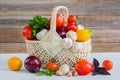 Fresh ripe organic vegetables in a wicker basket on a wooden table Royalty Free Stock Photo