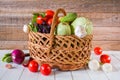 Fresh ripe organic vegetables in a wicker basket on a wooden table Royalty Free Stock Photo