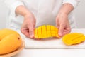 Fresh ripe organic yellow mangoes close up. Woman cutting mango on white cutting board Royalty Free Stock Photo