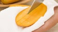 Woman cutting mango on white cutting board, preparing fruit salad Royalty Free Stock Photo