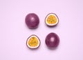 Fresh ripe passion fruits maracuyas on violet background, flat lay