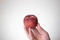 Fresh ripe peach held in hand by Caucasian male hand. Close up studio shot, isolated on a white background Royalty Free Stock Photo