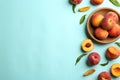 Fresh ripe peaches and green leaves on light blue background, flat lay. Space for text Royalty Free Stock Photo