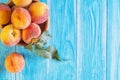 Fresh ripe peaches in a wooden bowl on a blue wooden background. Royalty Free Stock Photo